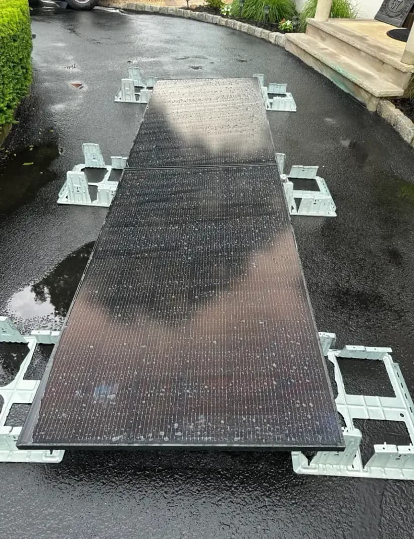 Ballasted mounting rails staged on the driveway before the Wayne NJ flat-roof install