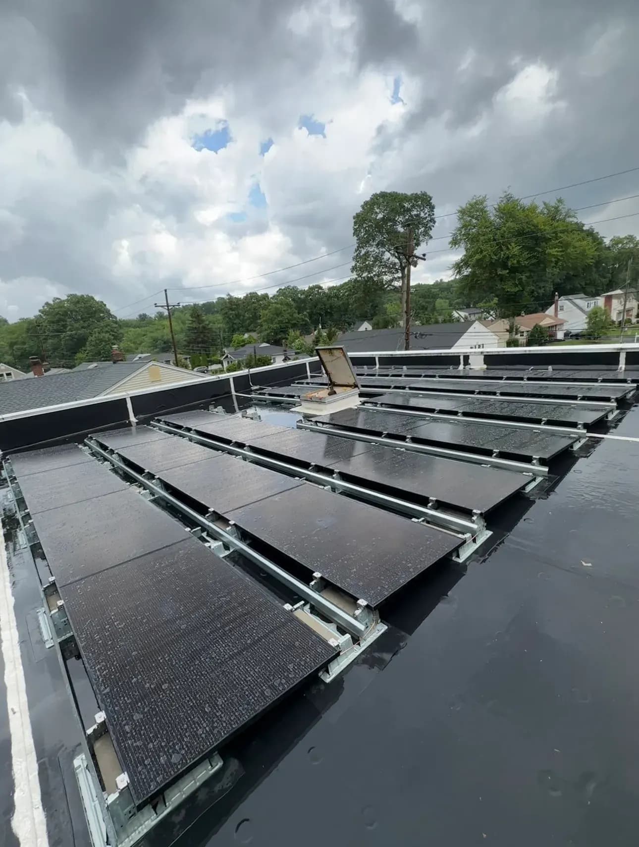 Rows of black solar panels on a real Fíor Solar flat-roof installation in Wayne, New Jersey