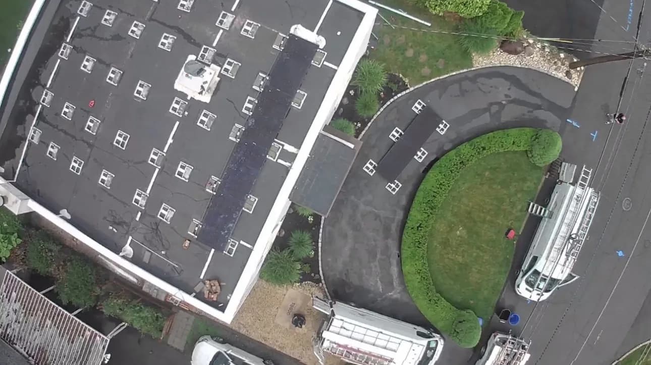 Aerial view of a real Fíor Solar flat-roof installation in Wayne, New Jersey, with the install crew on site